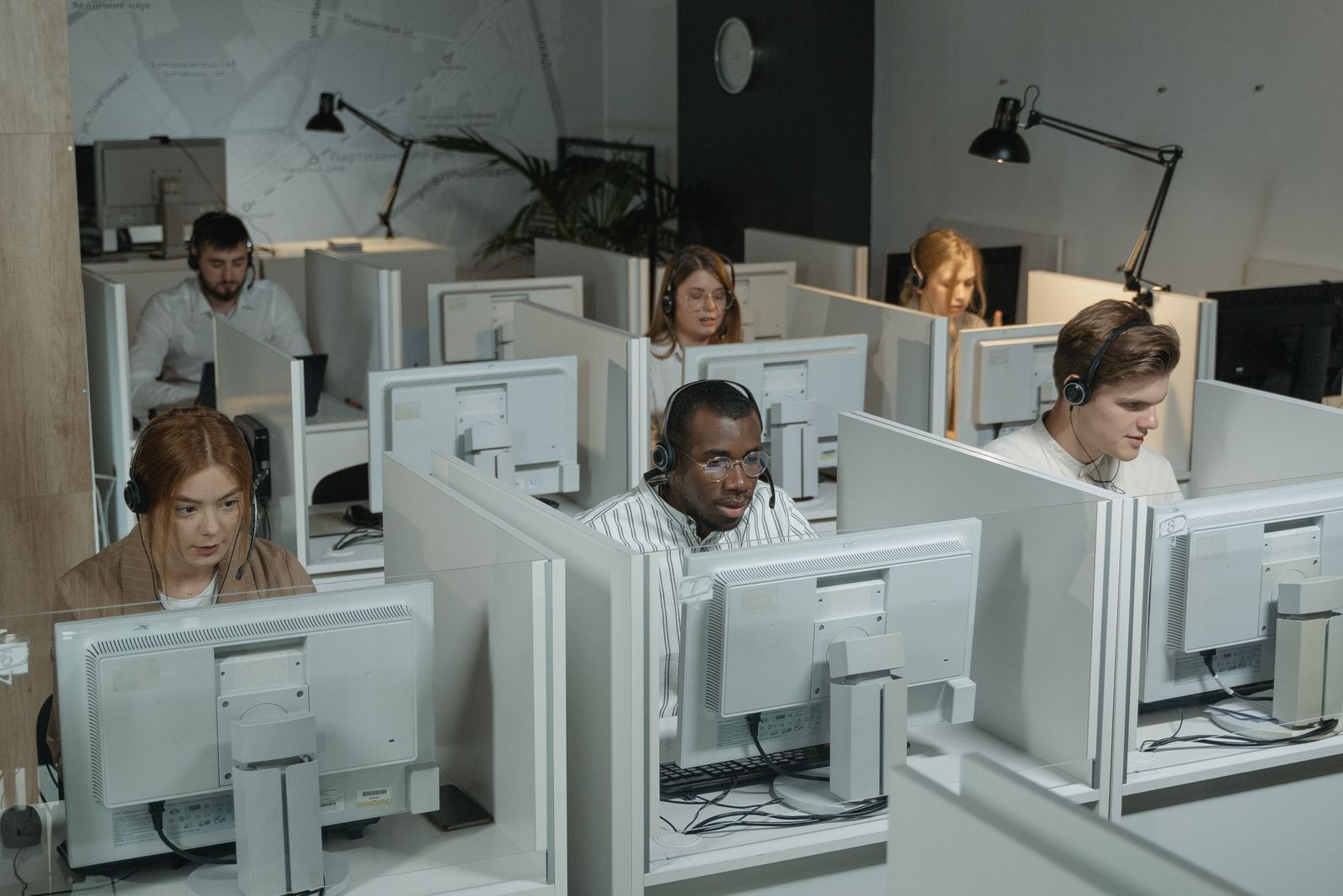 Mitarbeitende eines Kundenservice arbeiten mit Headsets