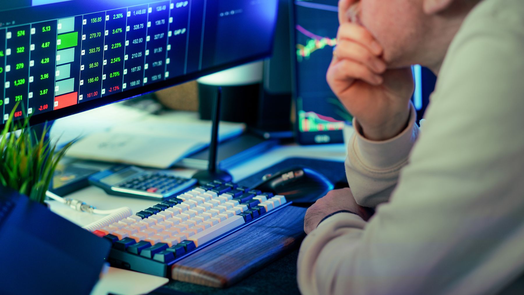 Händler analysiert Finanzmarktdaten auf mehreren Bildschirmen